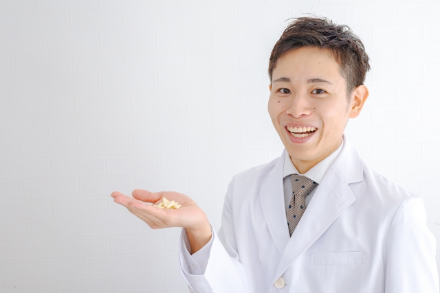 医薬品を手に持つ医師の画像